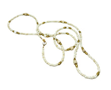 Load image into Gallery viewer, A handmade beaded necklace and matching bracelet made of small off-white beads with metallic gold spacer beads, displayed on a plain white background.