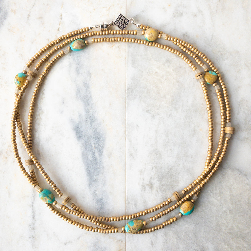 Warm sands, open vistas, blue sky.  Turquesa de la Tierra.  Turquoise of the Earth in Espanol.  Named for the beautiful Campitos turquoise from Mexico and the earthy handmade Columbian Clay beads, Turquesa de la Tierra exudes a warm, comforting energy.  Turquesa also features sandcast beads from Ghana, and matte 24k gold plated glass from Japan. Wraps may be worn as a necklace, choker, bracelet or anklet. US made magnetic clasp for easy styling.